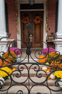 front steps adorned with mums and pumpkins